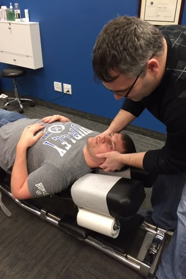 Dr. Nathan Weiss, D.C. performing a gentle neck adjustment at True North Chiropractic Center